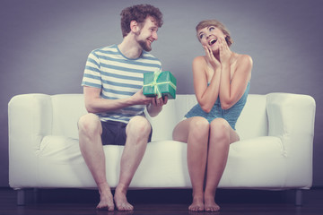 Obraz premium Young man giving woman gift box