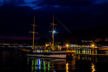 Fototapeta na wymiar Cruise ship in the harbor town , night landscape with bright lights