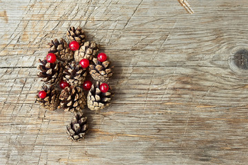 Christmas tree made out of cones on wooden background