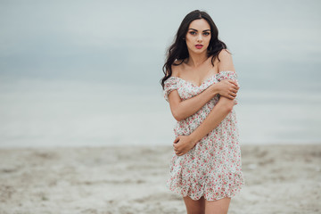 Beautiful and curly girl posing on a background of water