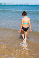 hübsches junges Mädchen läuft am Meer durchs Wasser