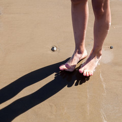 Füße eines jungen Mädchens am Sandstrand