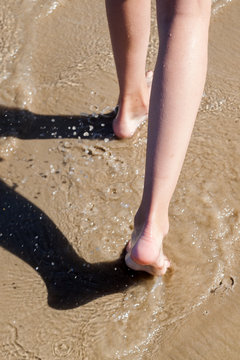 Beine eines jungen Mädchens dass am Strand läuft