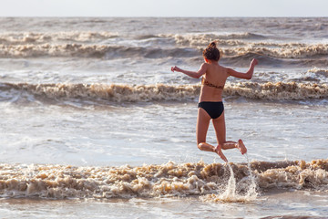 hübsches junges Mädchen spielt im Meer in Somerset, England
