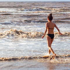 hübsches junges Mädchen spielt im Meer in Somerset, England