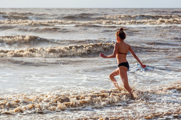 hübsches junges Mädchen spielt im Meer in Somerset, England