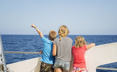 Fototapeta na wymiar Children look at the sea from the deck of a boat