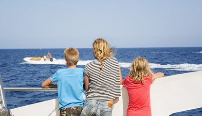 Fototapeta na wymiar Children look at the sea from the deck of a boat
