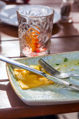 fast leer gegessener Teller mit Ravioli in einem Straßenrestaurant