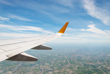 Wing of an airplane flying above the clouds