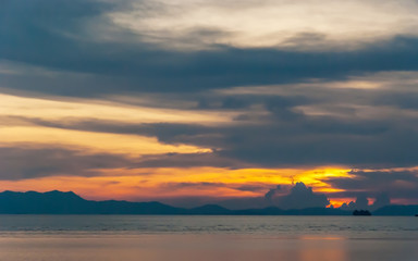 Fototapeta na wymiar Cloudy orange sunset over sea