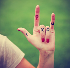 a young girl's hand with lettering i heart x o u written on  © annette shaff