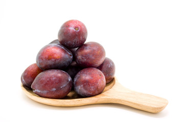 Fresh plums in wooden plate