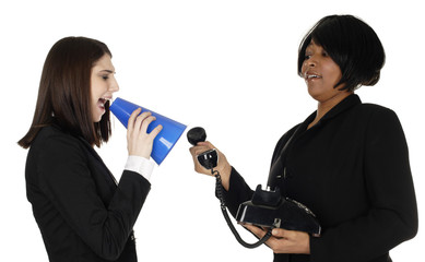 One woman yells through megaphone into a phone held by cringing second woman.