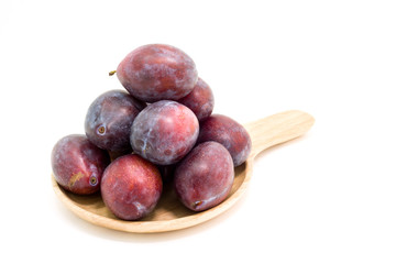 Fresh plums in wooden plate