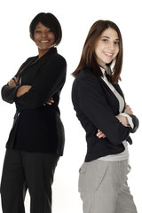 Two businesswomen standing with arms crossed. Focus is on woman in front.