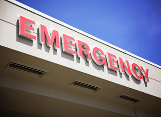 the front entrance sign to an emergency room department in a cit - Powered by Adobe