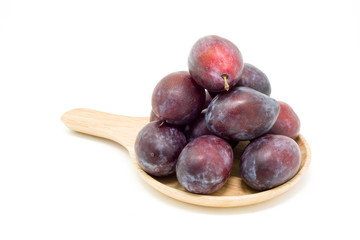 Fresh plums in wooden plate