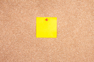 yellow reminder sticky note on cork board, empty space for text