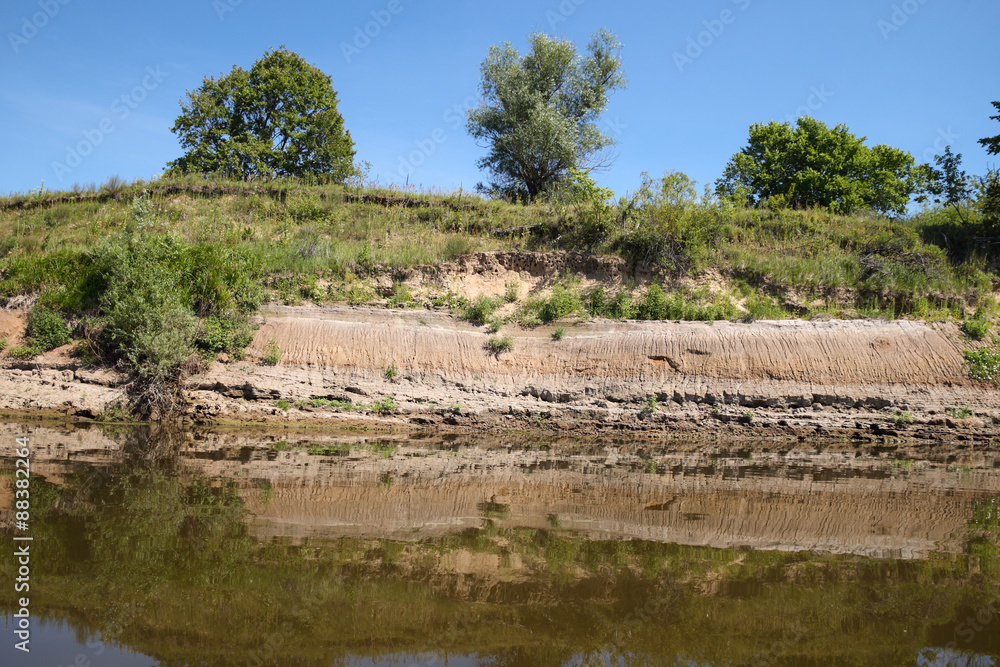 Wall mural river bank against a blue sky