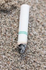Cigarette butts in the sand on beach
