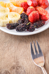 Healthy fresh fruits in a plate, orange, banana, strawberry, mul