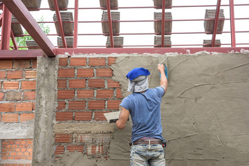 Builder worker plastering  concrete at wall