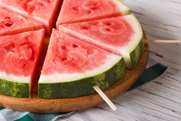 slices of watermelon on a stick close up on the table. horizontal

