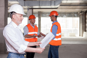 Cheerful construction team is discussing a new project