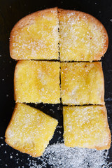 Bread with butter on black background