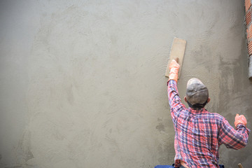 Builder worker plastering  concrete at wall