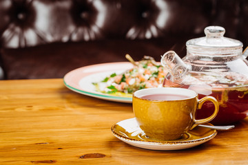 cup of tea and kettle  on wooden background