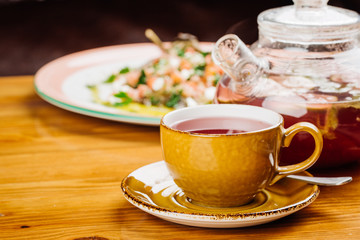 cup of tea and kettle  on wooden background