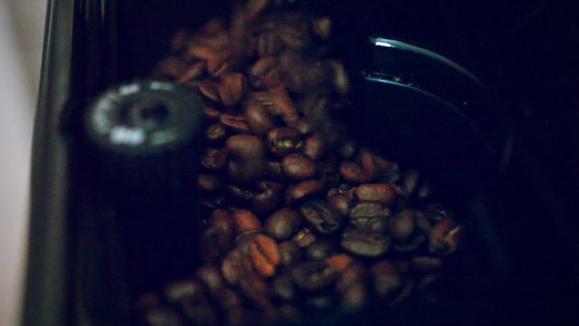 putting some coffee beans in the coffee machine