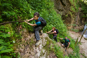 Obraz premium Hikers climbing on a safety cable
