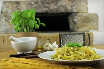 Zutaten und Untensilien für Pesto - Mörser, Pistill, Käsereibe, Küchenbrett, Olivenöl,...