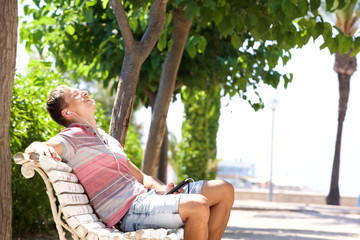 Happy young man enjoying music from mobile phone