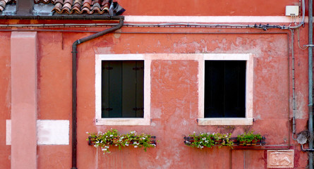 Fototapeta na wymiar two windows and drained pipe with coral color wall