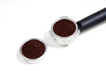 Portafilter filled with ground coffee on a white background