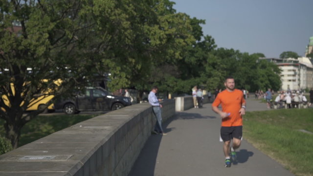 Man takes break and drinks water during the jogging.
