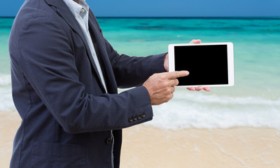 Businessman hands holding tablet computer with seascape backgrou