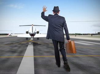 Business man running behind a plane