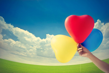 Fototapeta na wymiar Vintage color tone style, balloon heart shape on the grass field
