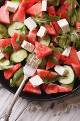 salad of watermelon, cheese, arugula and cucumbers closeup. Vertical
