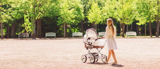 happy mother with stroller in park