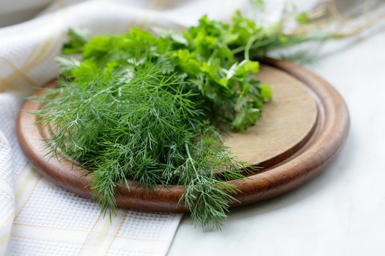 Fresh dill and parsley on a cutting board. Selective focus.