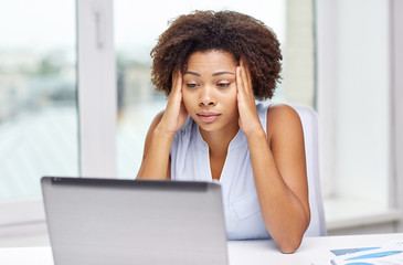 african woman with laptop at office