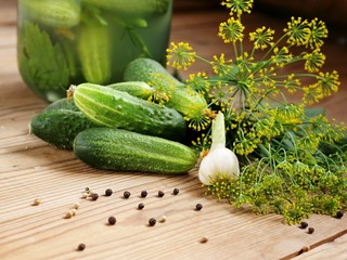 Fresh and pickled cucumbers on wooden background. Selective focus