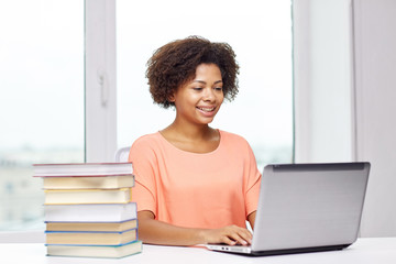 happy african american woman with laptop at home