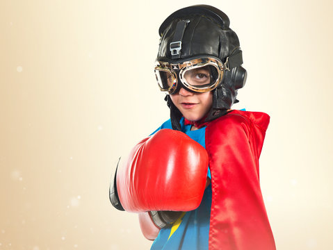 Confident child dressed like superhero with boxing gloves
